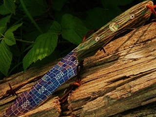 dagger with purple damascus blade and old wood handle with decorations embedded