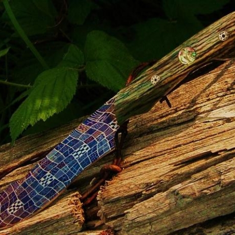 dagger with purple damascus blade and old wood handle with decorations embedded