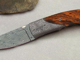 knife made with interlocking damascus pattern and dark wood handle