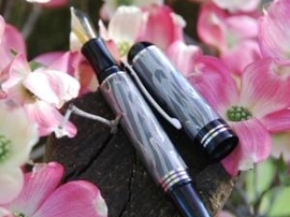 elegant damascus encased fountain pen amoung flowers