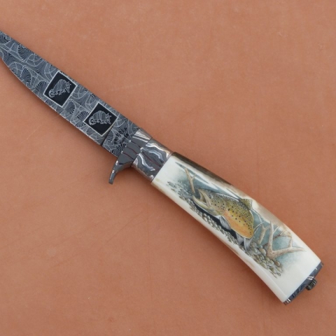 knife with armadillos on the blade and salmon on the handle