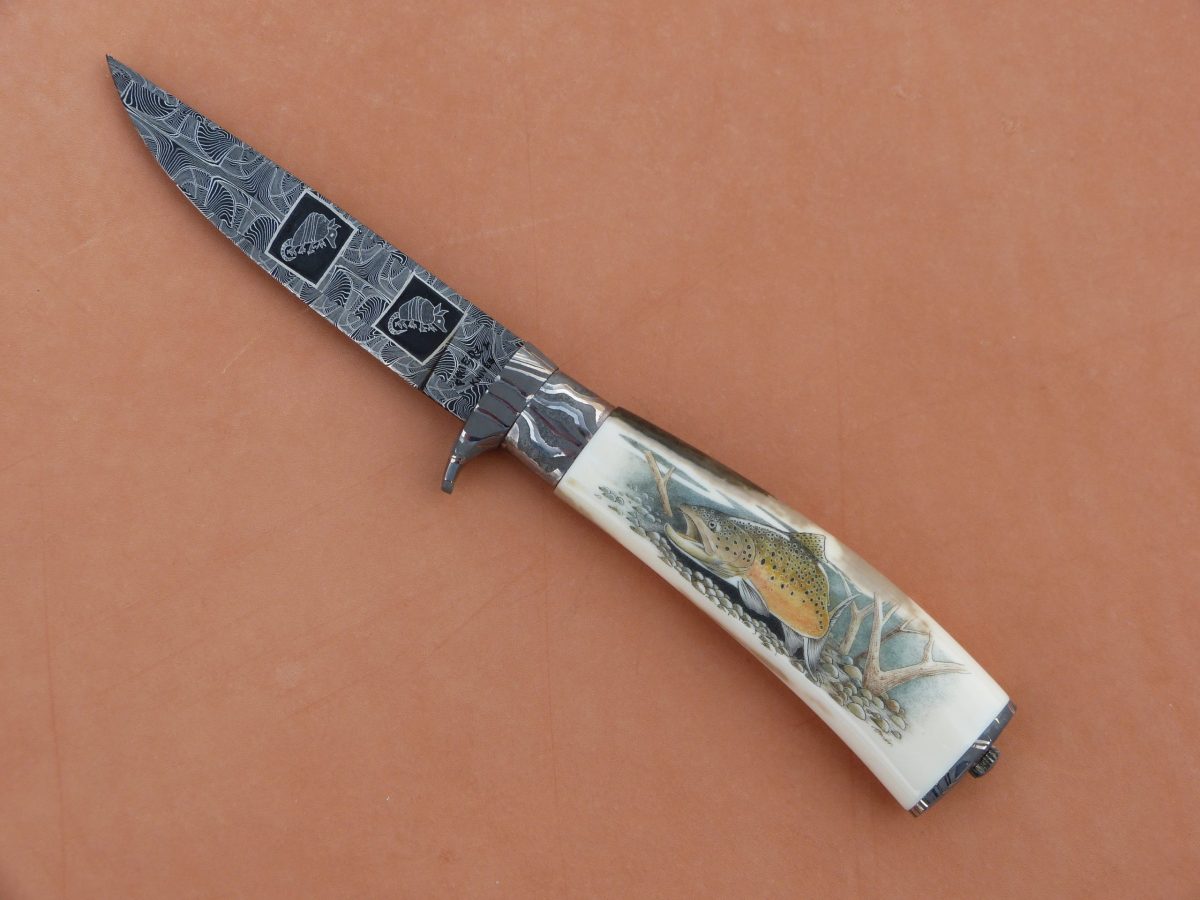 knife with armadillos on the blade and salmon on the handle
